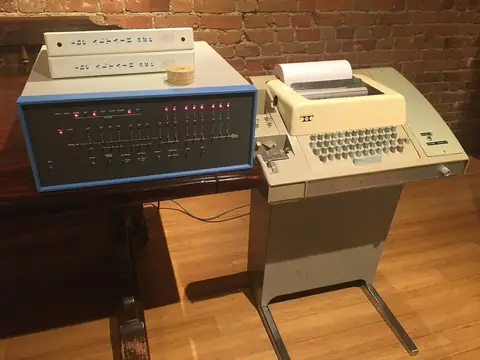 Altair 8800 接上 Model 33 电传打字机：拨完引导程序、把 BASIC 读进去之后，人终于能“打字”了。