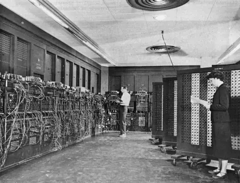 1945 年，Glen Beck 与 Betty Snyder 在 ENIAC 前接线。那时的“编程”，就是插线和拨开关。
